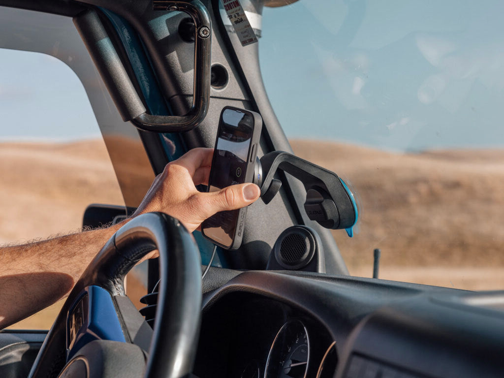 Off road car mount with wireless charging head attached to windscreen with iPhone