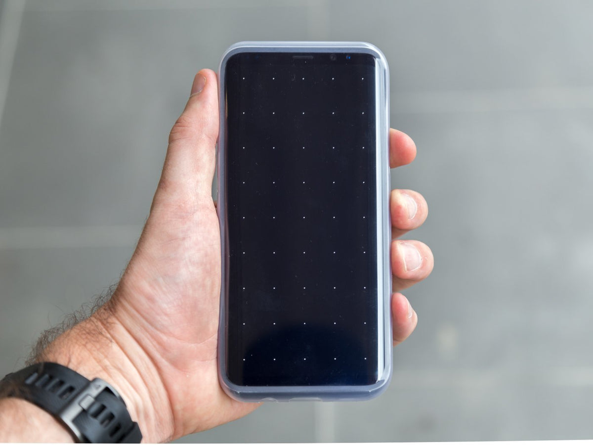 samsung galaxy with quad lock case and poncho held in hand