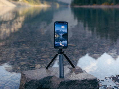 Quad Lock tripod adaptor with iPhone mounted and attached to tripod taking a photo of mountains